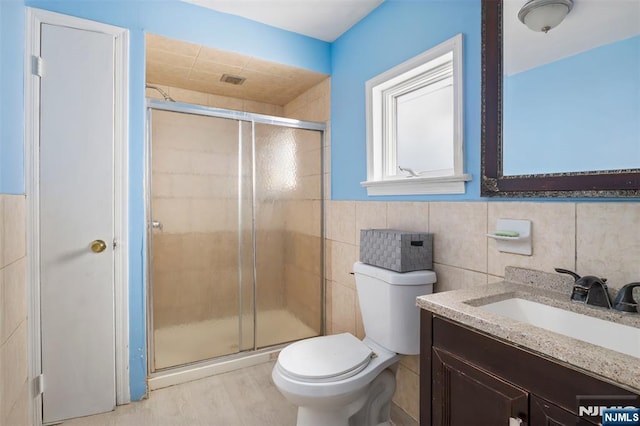 23 Foundry St, Newark, NJ 07105 - bathroom featuring a shower stall, wood finished floors, toilet, vanity, and tile walls