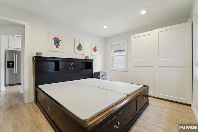 kitchen featuring light countertops, stainless steel refrigerator with ice dispenser, recessed lighting, and light wood-style floors