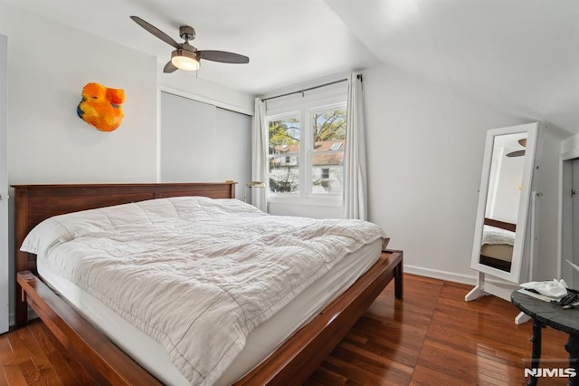 bedroom featuring baseboards, ceiling fan, vaulted ceiling, and wood finished floors
