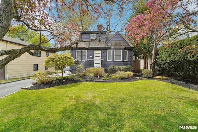 view of front of property featuring a chimney and a front yard