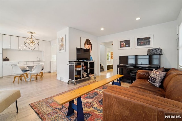 living room with stairway, recessed lighting, and light wood-style flooring