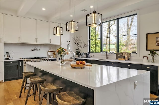 kitchen with a center island, light wood-style flooring, a sink, and a wealth of natural light