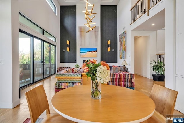 dining area featuring a towering ceiling, a healthy amount of sunlight, and baseboards