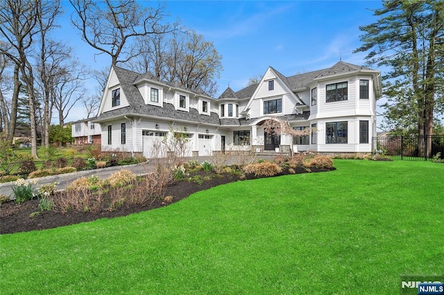 shingle-style home with fence, driveway, a front yard, and a garage