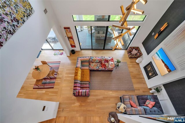 living area with a towering ceiling and wood finished floors