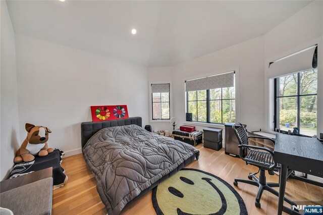 bedroom with wood finished floors, recessed lighting, and multiple windows