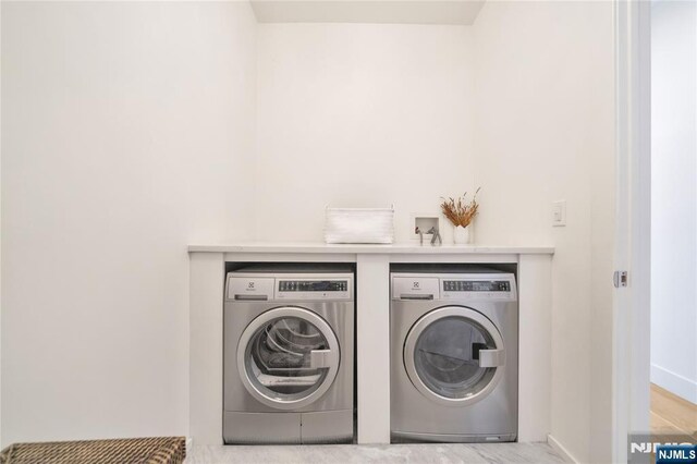 laundry room with baseboards, washing machine and clothes dryer, and laundry area
