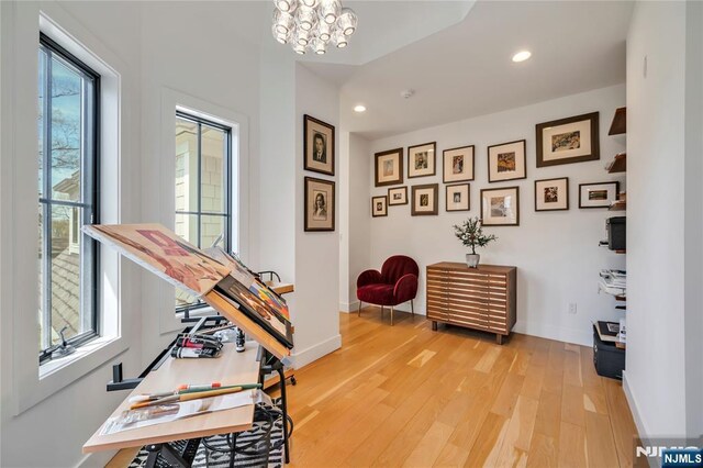 interior space featuring baseboards, light wood-type flooring, a notable chandelier, and recessed lighting