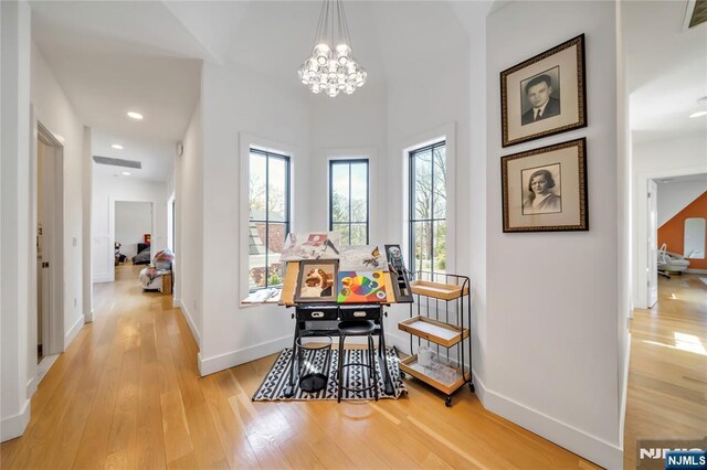 hall with visible vents, baseboards, an inviting chandelier, light wood-type flooring, and recessed lighting