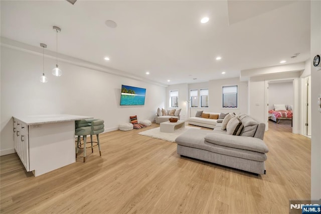 living room featuring recessed lighting, light wood-style flooring, and baseboards