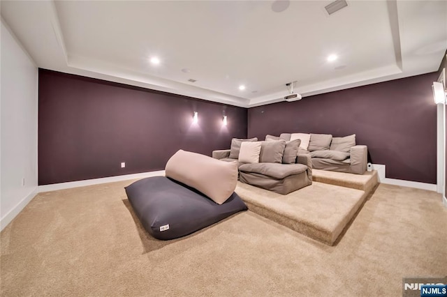 carpeted home theater with recessed lighting, a tray ceiling, and baseboards