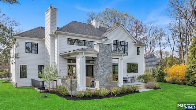 back of property featuring a lawn, a chimney, and a patio area