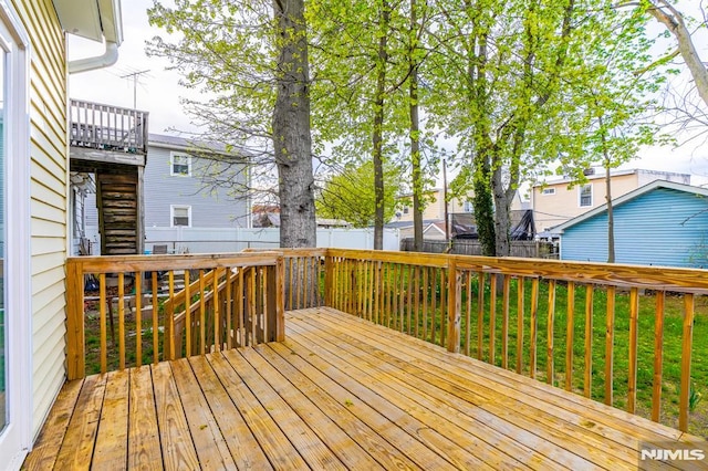 deck with a lawn and a fenced backyard