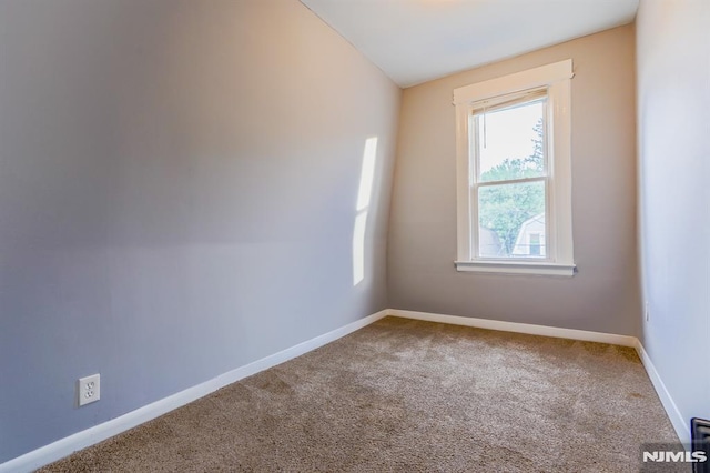 empty room featuring carpet floors and baseboards