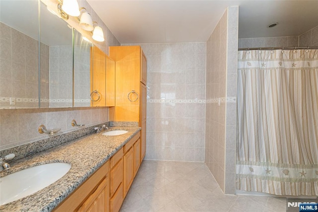 full bath featuring tile patterned flooring, a sink, and double vanity