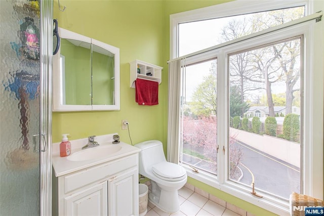 bathroom with toilet, vanity, and tile patterned floors