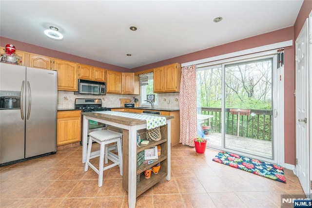 kitchen with decorative backsplash, stainless steel appliances, and light tile patterned floors