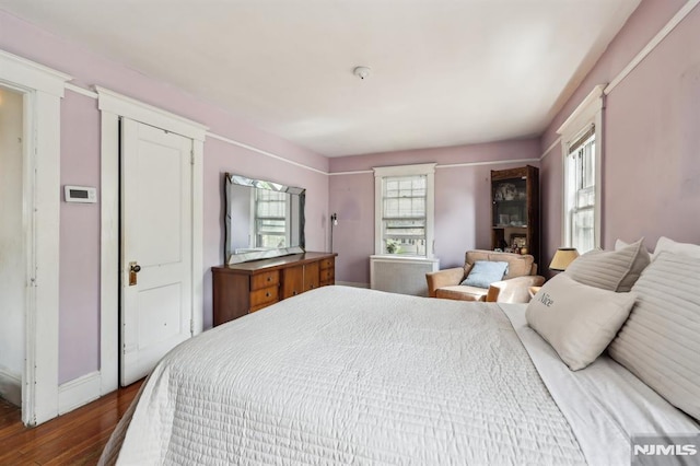 bedroom with baseboards and wood finished floors