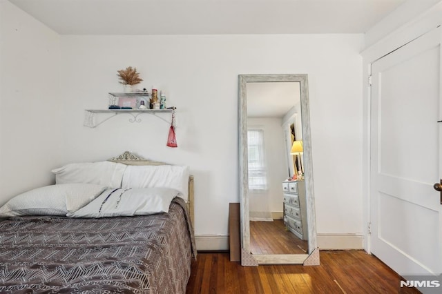 bedroom with baseboards and wood finished floors