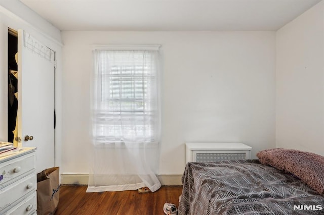 bedroom featuring baseboards and dark wood finished floors