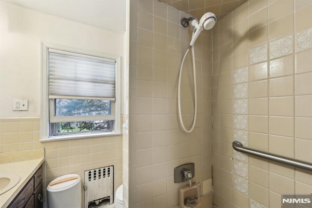 bathroom with vanity, toilet, tile walls, washtub / shower combination, and radiator heating unit