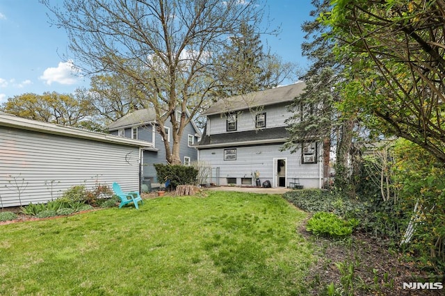 rear view of property with a yard