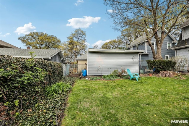 back of house featuring a lawn and fence