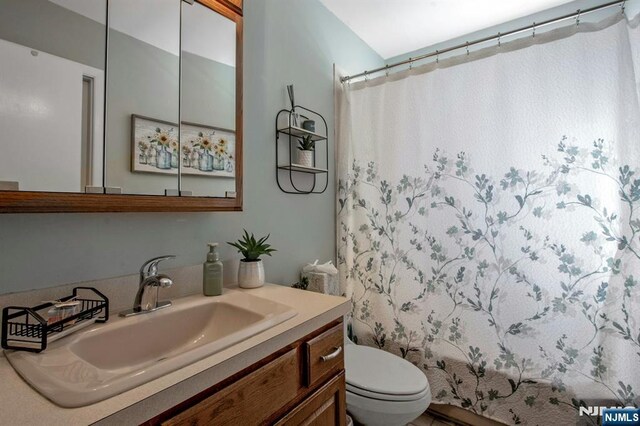 full bath featuring vanity and toilet