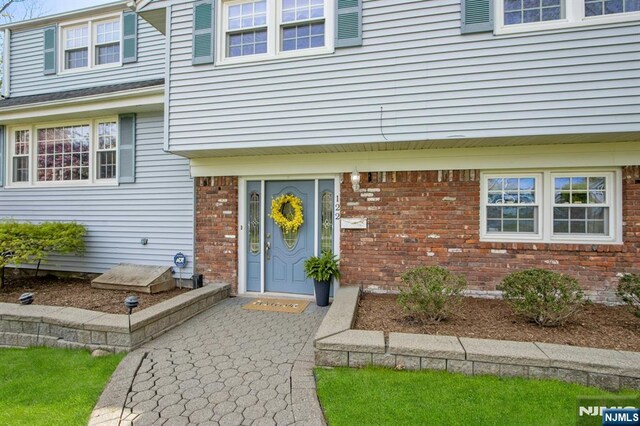 view of exterior entry with brick siding