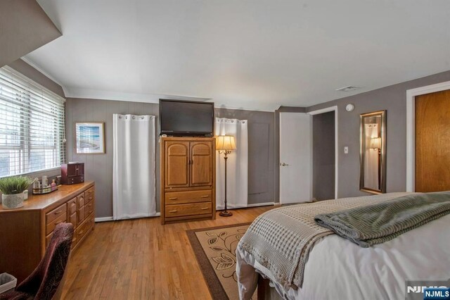 bedroom with light wood-type flooring and baseboards