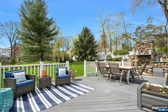 wooden deck featuring a yard, fence, and outdoor dining space