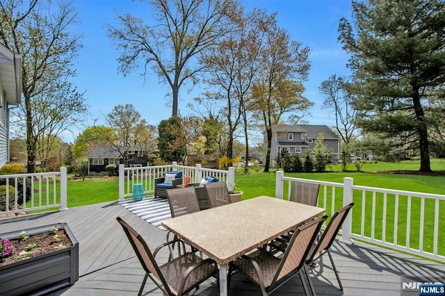 wooden terrace with outdoor dining area and a yard