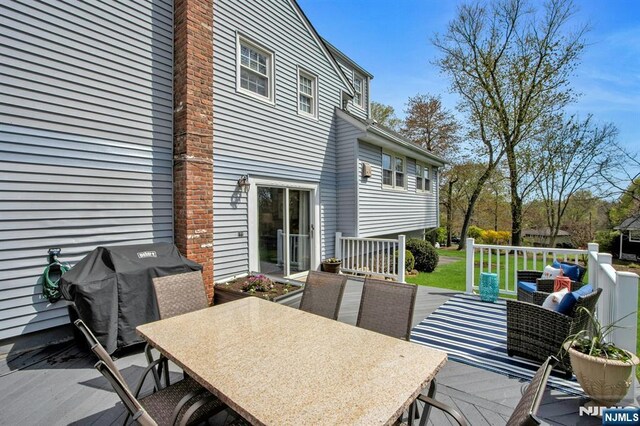 deck with a grill and outdoor dining area