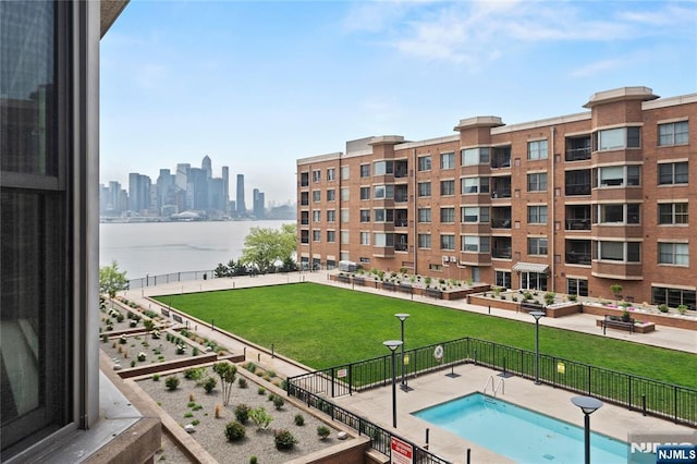 community pool featuring a water view and a skyline view