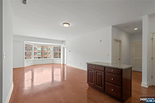 unfurnished living room featuring wood finished floors and baseboards