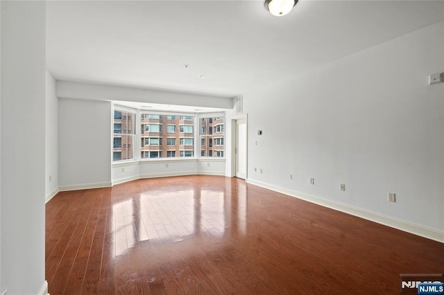 spare room with wood finished floors and baseboards