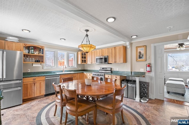 kitchen featuring dark countertops, a textured ceiling, a sink, appliances with stainless steel finishes, and ornamental molding