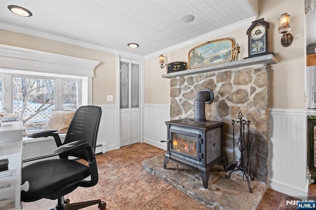 home office featuring a wainscoted wall, a wood stove, crown molding, a textured ceiling, and baseboard heating