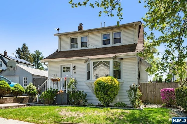 view of front of house with fence, a front yard, and a chimney