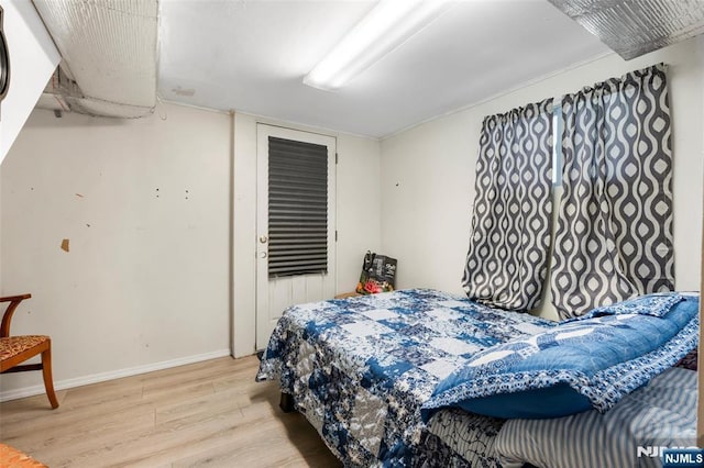 bedroom with baseboards, wood finished floors, and a closet