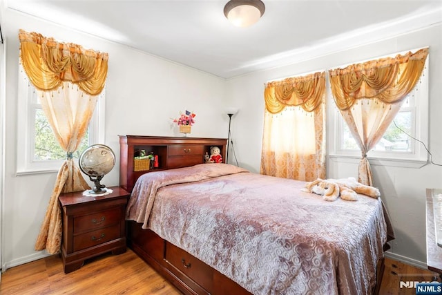 bedroom with baseboards and light wood-type flooring