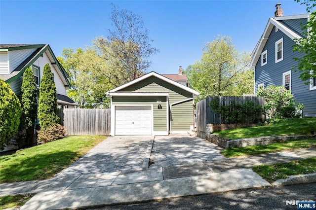 garage with fence and driveway