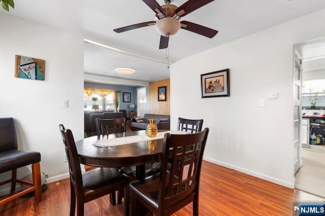 dining room featuring baseboards, ceiling fan, and wood finished floors