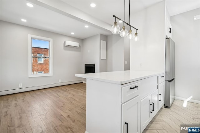 kitchen featuring white cabinets, baseboard heating, freestanding refrigerator, and a wall mounted AC
