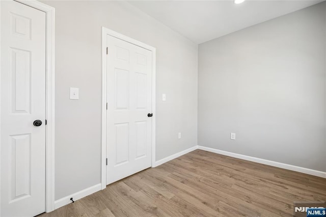 unfurnished bedroom featuring recessed lighting, wood finished floors, and baseboards