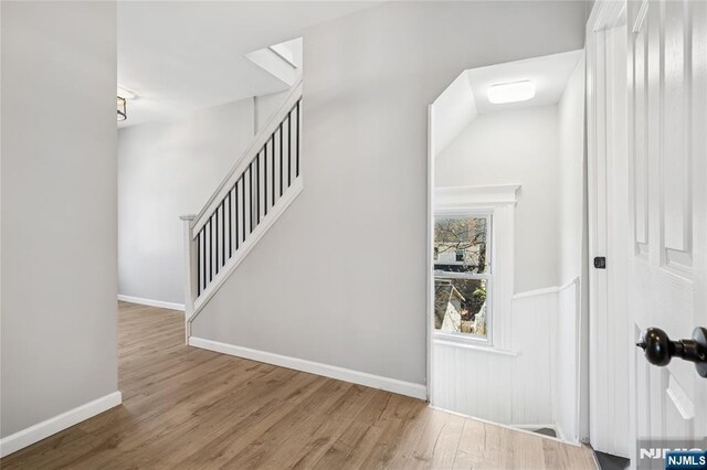 stairs featuring wood finished floors and baseboards