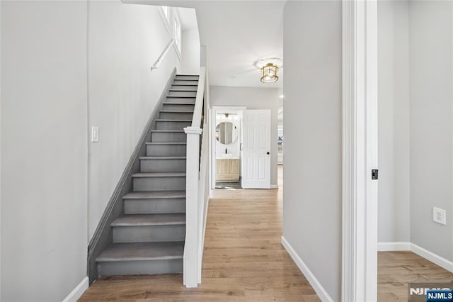 stairway with wood finished floors and baseboards