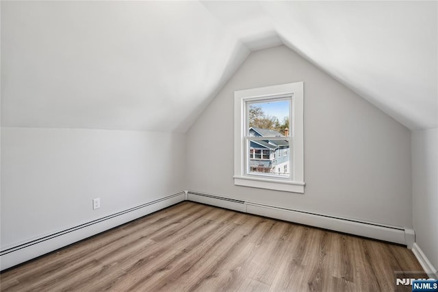 bonus room featuring a baseboard radiator, vaulted ceiling, and wood finished floors