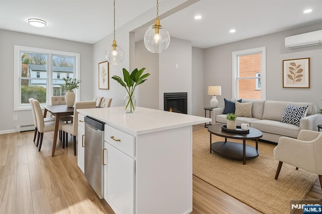 kitchen with white cabinets, light wood finished floors, a wall mounted AC, and recessed lighting