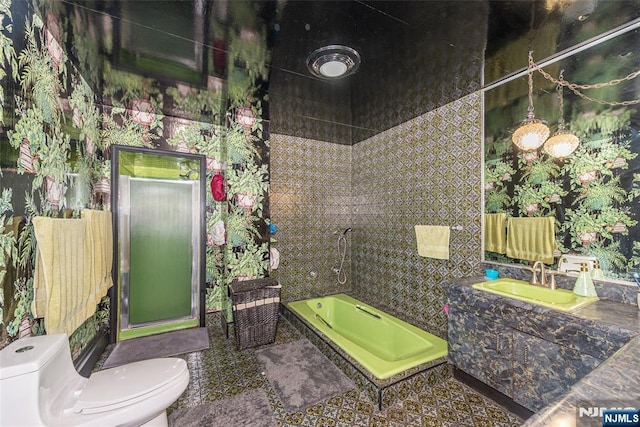 full bathroom featuring wallpapered walls, toilet, vanity, a garden tub, and a stall shower